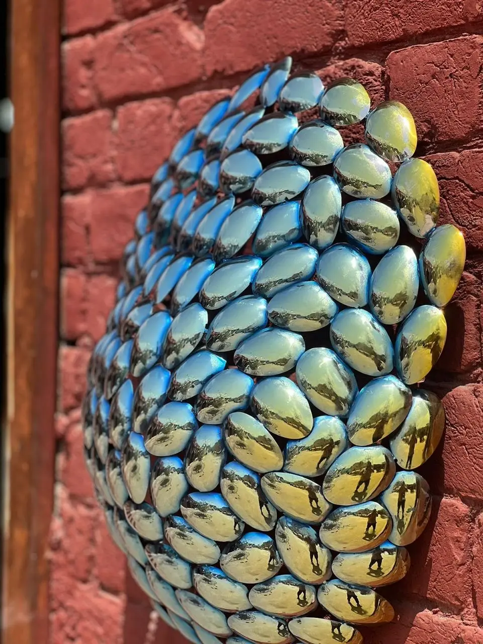 Scaled organic wall sculpture in iridescent metal