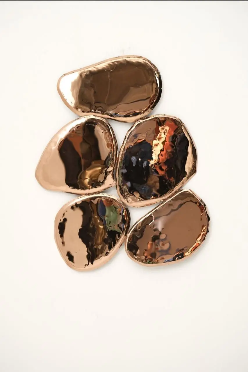 Cluster of rose-gold mirror-polished pebble forms